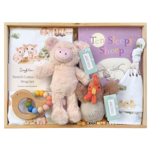 ROOM TO BLOOM Animal Farm Baby Gift Hamper set with plush toys, book, and other baby items in a wooden box.