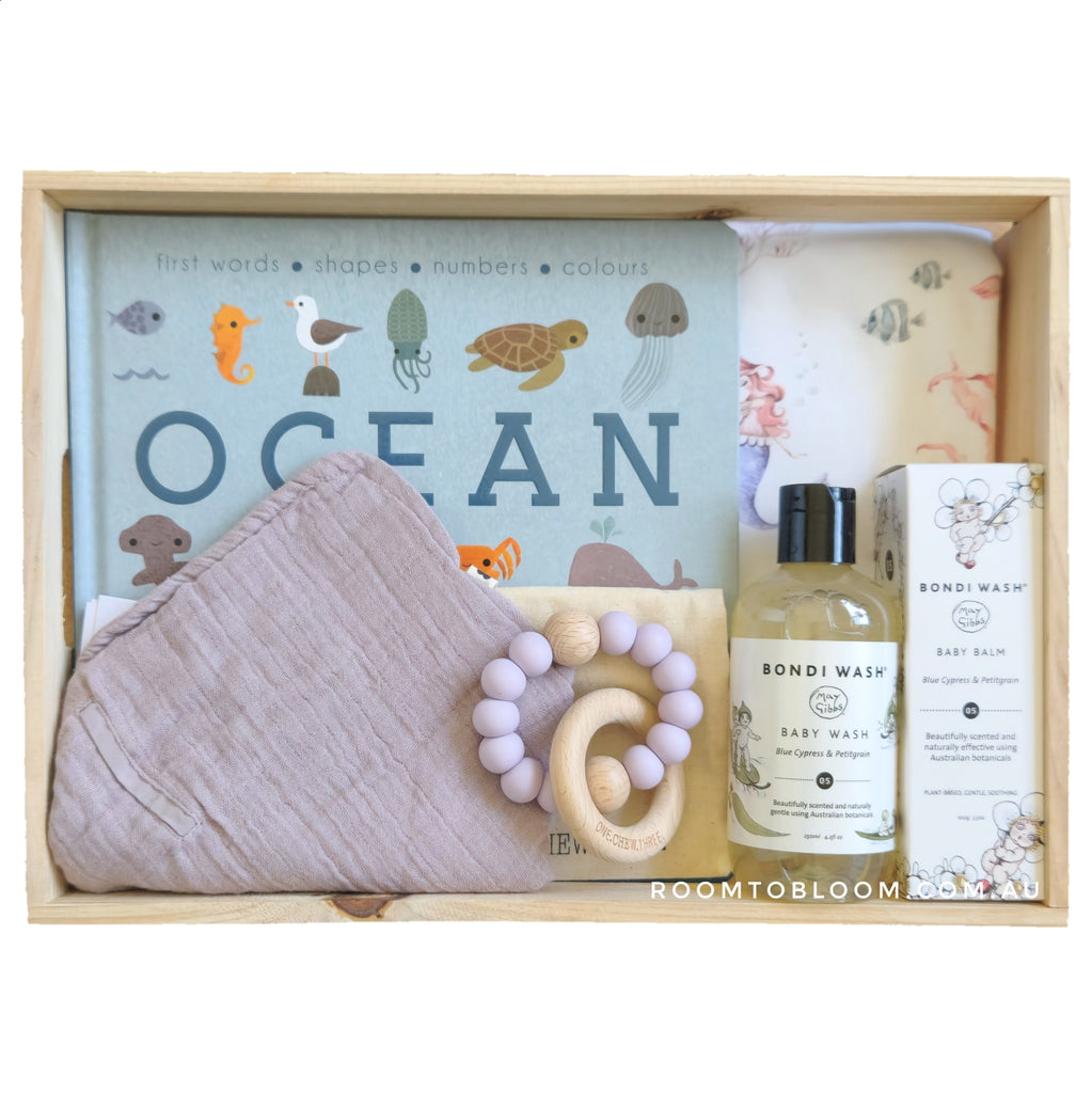 ROOM TO BLOOM Aqua Girl Baby Gift Hamper set with 'Ocean' themed items and bath products in a wooden box.
