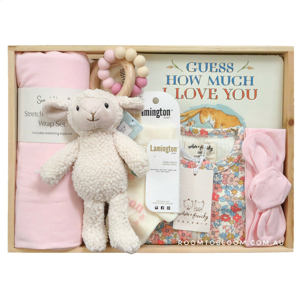 ROOM TO BLOOM Blossoming Baby Gift Hamper set with plush lamb, pink swaddle, and other items in a wooden box.