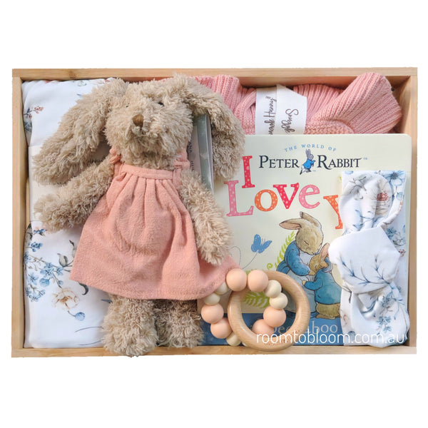 ROOM TO BLOOM Bluebirds Baby Gift Hamper set in a wooden box featuring a Peter Rabbit book, a pink knitted blanket, a wooden bead teether, a swaddle, headband and plush rabbit.