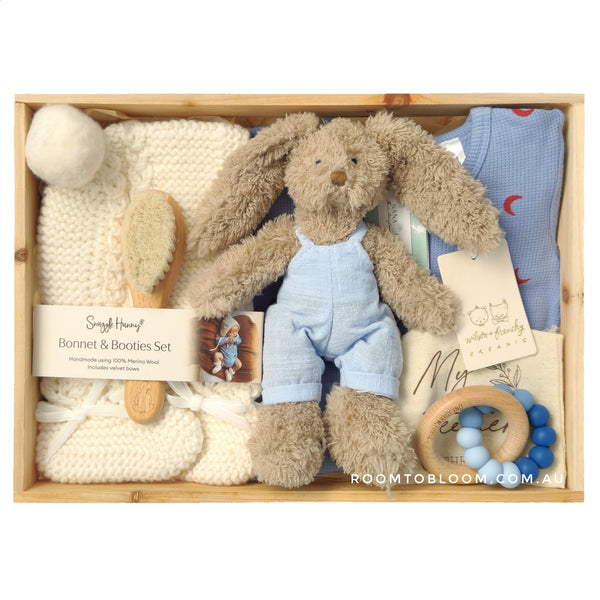 ROOM TO BLOOM Bunny Hop Baby Gift Hamper gift set with plush toy, knitted items, and baby accessories in a wooden box.