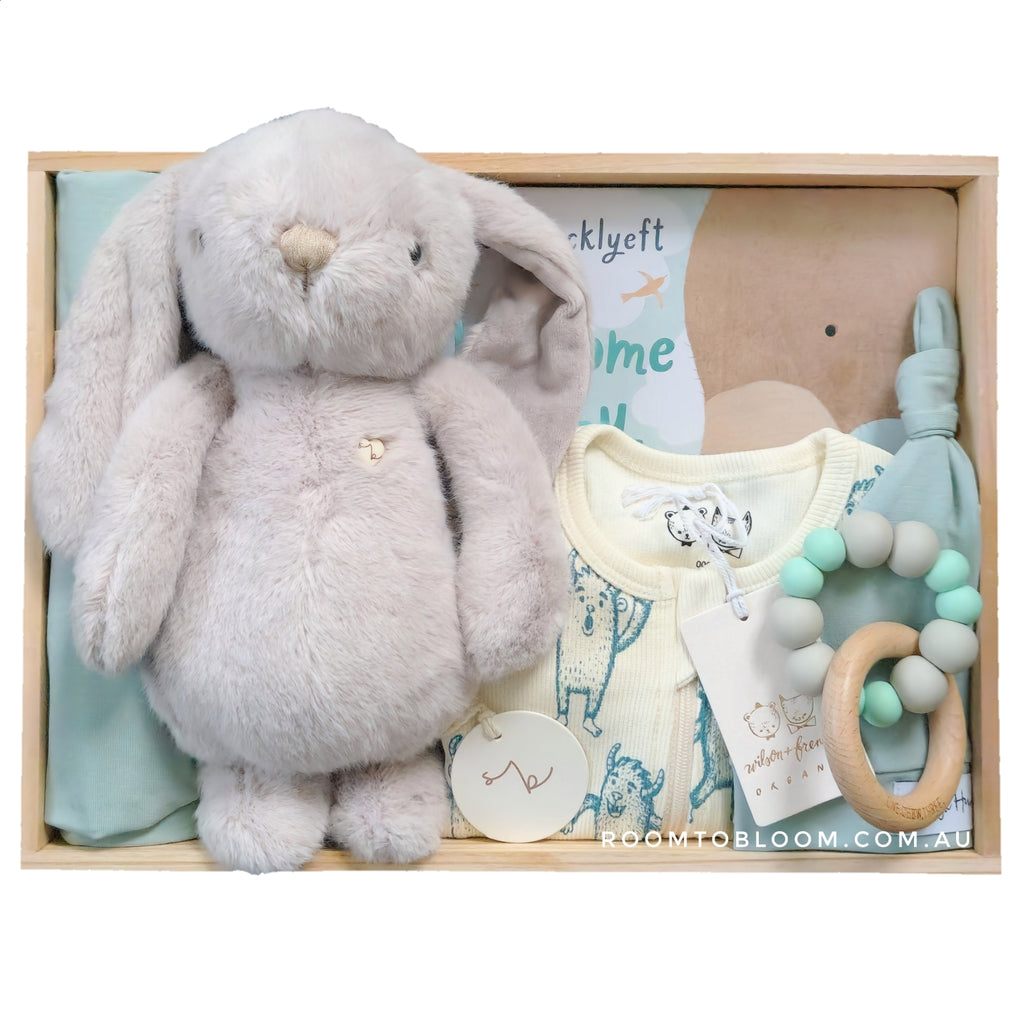 Baby gift set with plush rabbit, baby clothes, teething ring and more in a wooden box.