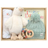 ROOM TO BLOOM Chelsea Baby Gift Hamper set in a light wood box featuring a plush cream goose toy, a mint green cable-knit pom-pom hat, a wooden bead teething ring, a folded patterned swaddle, and a Peter Rabbit book.