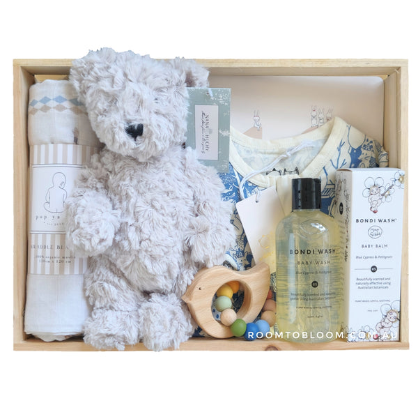 ROOM TO BLOOM Circus Fun Baby Gift Hamper set with teddy bear, baby items, and bath products in a wooden box.
