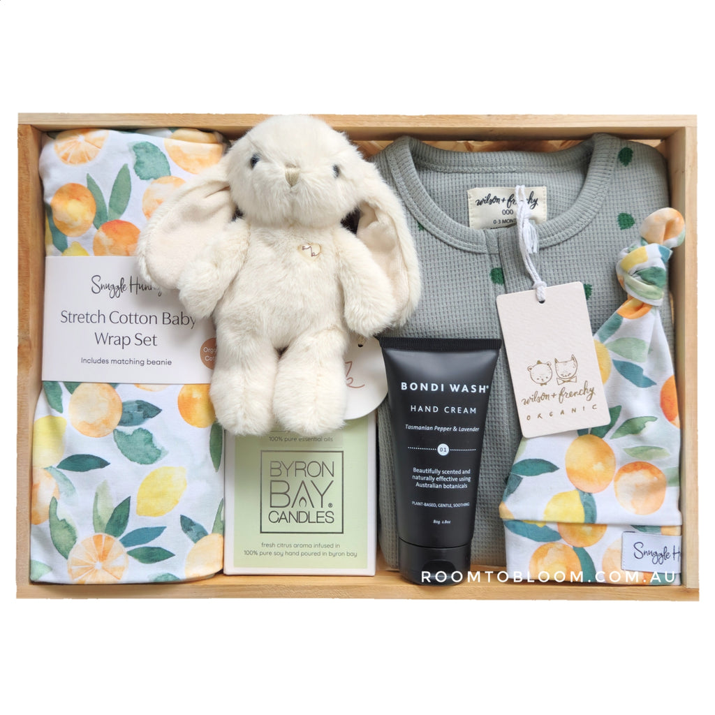 ROOM TO BLOOM Citrus Surprise Baby Gift Hamper set with plush toy, baby clothes, candle and more in a wooden box.