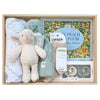ROOM TO BLOOM Four Seasons Baby Gift Hamper set arranged in a light wood box, featuring a cream plush sheep, a mint green knit beanie, a folded white swaddle, Lamington socks, a children's book titled 'Each Peach Pear Plum', and pacifiers.