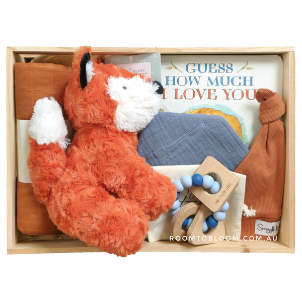 ROOM TO BLOOM Fox on the Run Baby Gift Hamper set with plush fox toy, baby book, and other items in a wooden box.