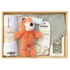 ROOM TO BLOOM Fox Tot Baby Gift Hampert set arranged in a light wood box, featuring a plush orange fox toy, a white muslin wrap, a pale green muslin bib, a white blanket, Lamington socks and pacifiers.
