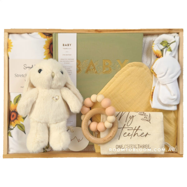 ROOM TO BLOOM Here Comes the Sun Baby Gift Hamper set with plush toy, teether, and other items in a wooden box.