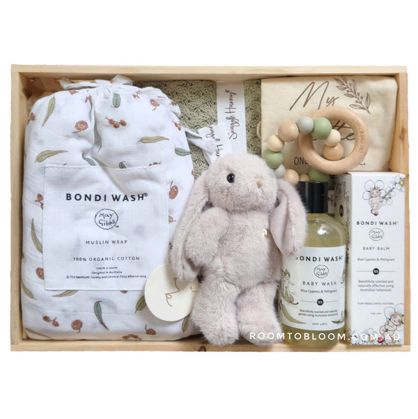 ROOM TO BLOOM Little Gumnut Baby Gift Hamper set with items including a muslin wrap, plush toy, bath products and more in a wooden box.