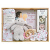 ROOM TO BLOOM Little Rabbit Baby Gift Hamper set arranged inside a wooden box, featuring a plush beige bunny toy, a pink and white floral baby wrap blanket and headband, a wooden ring teether with pink and cream beads, a book titled 'Ten Little Fingers and Ten Little Toes', and a boxed pacifier set.
