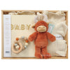 ROOM TO BLOOM Milestones Baby Gift Hamper set in a light wood box featuring a plush orange-brown stuffed animal, cream knit baby blanket, a wooden bead teether, and a cream baby book with gold 'BABY' lettering.