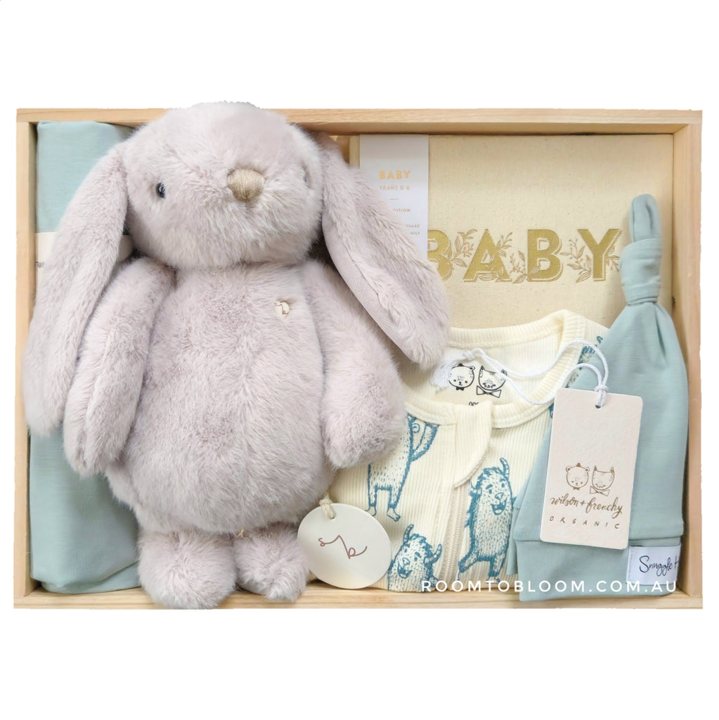 ROOM TO BLOOM Monster Mash Baby Gift Hamper set with plush bunny, baby clothes, and other items in a wooden box.