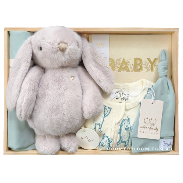 ROOM TO BLOOM Monster Mash Baby Gift Hamper set with plush bunny, baby clothes, and other items in a wooden box.