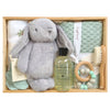 ROOM TO BLOOM Oasis Baby Gift Hamper set arranged in a light wood tray, featuring a plush grey bunny, a mint green textured towel, a bottle of Bondi Wash baby wash, a wooden teething ring with mint and white beads, a wooden baby brush, and folded muslin and sage baby blanket. 