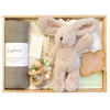 ROOM TO BLOOM Olea Baby Gift Hamper set arranged in a light wood box, featuring a beige plush bunny toy, a rolled green muslin wrap, a cream knit growsuit, wooden bead teething ring, an ivory bib and a candle.