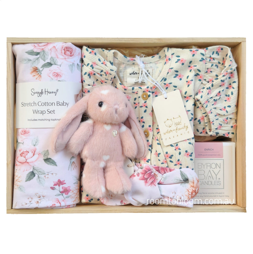 ROOM TO BLOOM Pretty Petal Baby Gift Hamper set in a light wood box featuring a pink plush bunny, a floral baby wrap set, a floral baby dress, and a Byron Bay candle.