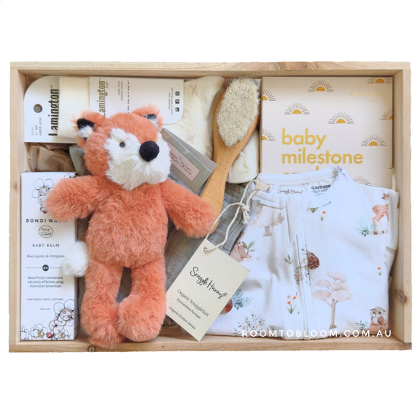 ROOM TO BLOOM Redwood Forest Baby Gift Hamper set with fox plush toy, baby milestone cards, and other items in a wooden box.