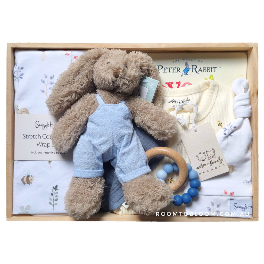 ROOM TO BLOOM Secret Garden Baby Gift Hamper set with plush toy, baby clothing, and other items in a wooden box.