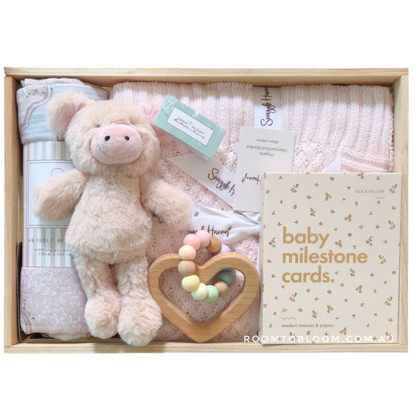 ROOM TO BLOOM Tickled Pink Baby Gift Hamper set with plush toy, milestone cards, and other items in a box.