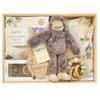 ROOM TO BLOOM Treasure Island Baby Gift Hamper set in a light wood box featuring a plush grey monkey toy, a stretch cotton baby wrap and beanie set with palm tree and nautical designs, a cream printed zipsuit, wooden teething ring, mittens and pacifiers.