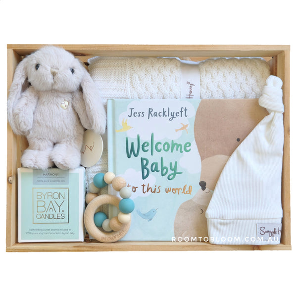 ROOM TO BLOOM Welcome to the World Baby Gift Hamper set with plush toy, book, and other items in a wooden box.