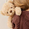 Person wearing a brown sweater holding a beige SNUGGLE BUNNIES Arthur the Bear against a neutral background