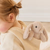 Child wearing a beige knit sweater with a plush SNUGGLE BUNNIES Little Penelope - Beige toy on a neutral background