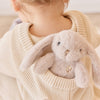 Child holding a plush SNUGGLE BUNNIES Little Penelope - Beige toy with a neutral background