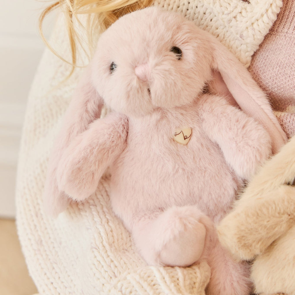 Person holding a SNUGGLE BUNNIES Little Penelope - Blossom toy with a soft background