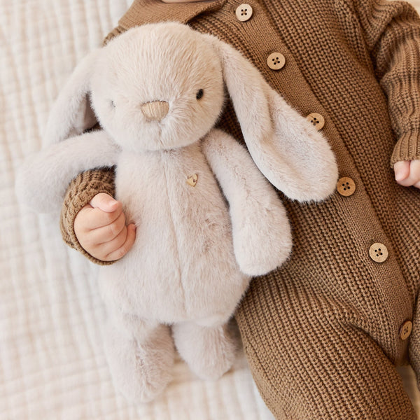 Child holding a plush SNUGGLE BUNNIES Penelope - Beige toy