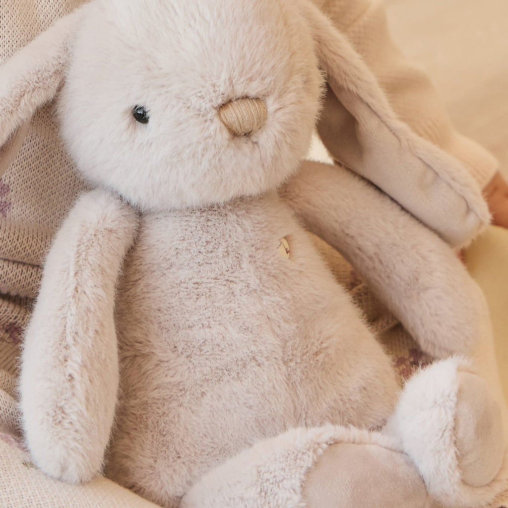 Plush SNUGGLE BUNNIES Penelope - Beige toy on a soft, patterned fabric background