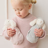 Child holding two SNUGGLE BUNNIES against a light background