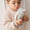 Child holding a SNUGGLE BUNNIES Sleeping Penelope toy against a neutral background